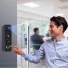 Slim access controller mounted beside a glass door with user interacting via keypad