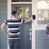 Smart key box mounted beside a front door being accessed with the keypad